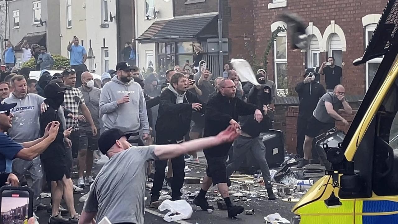 An unruly crowd clash with police in Southport, England