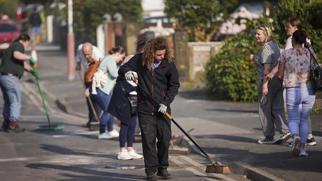 Volunteers sweep Sussex Road in Southport, England