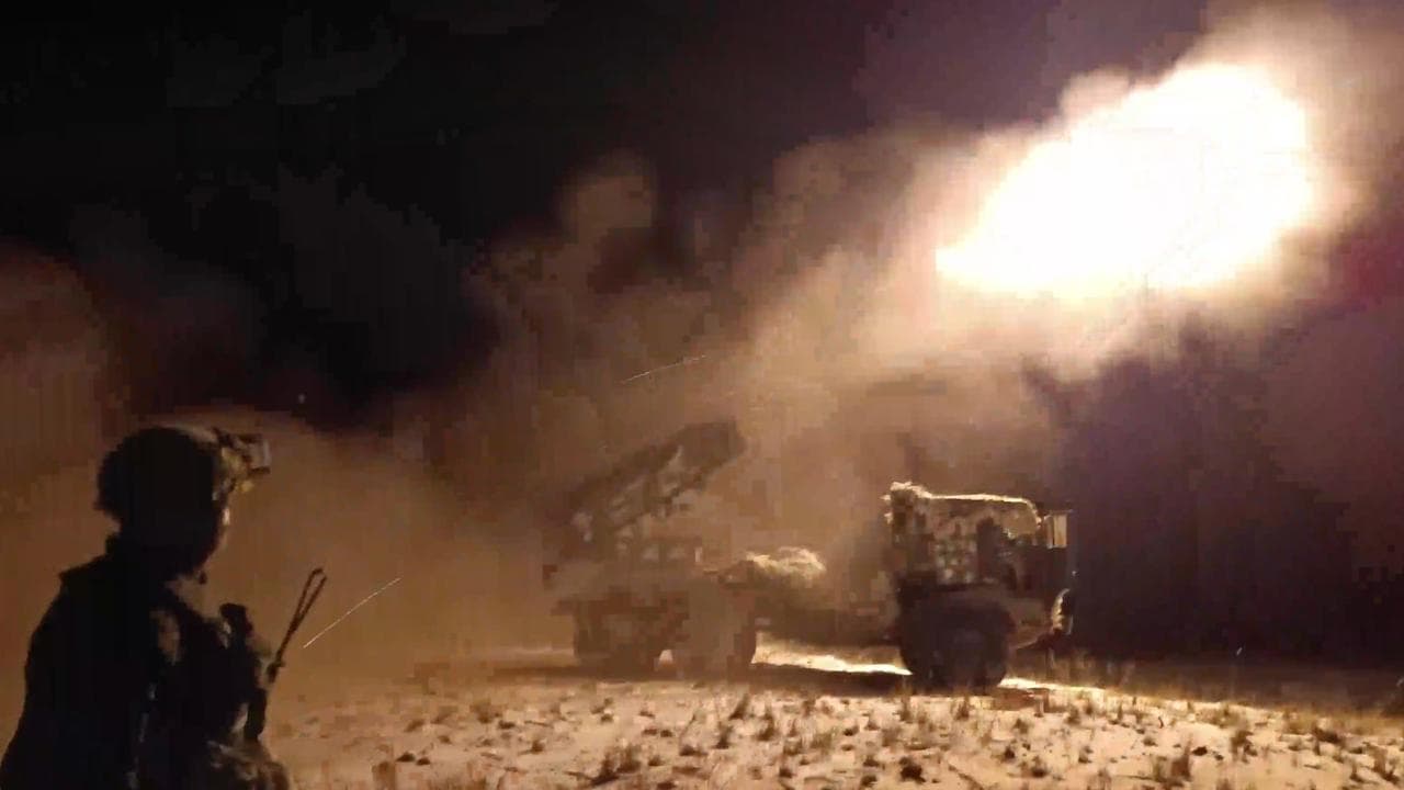 Russian soldiers fire from a 122mm multiple rocket launcher