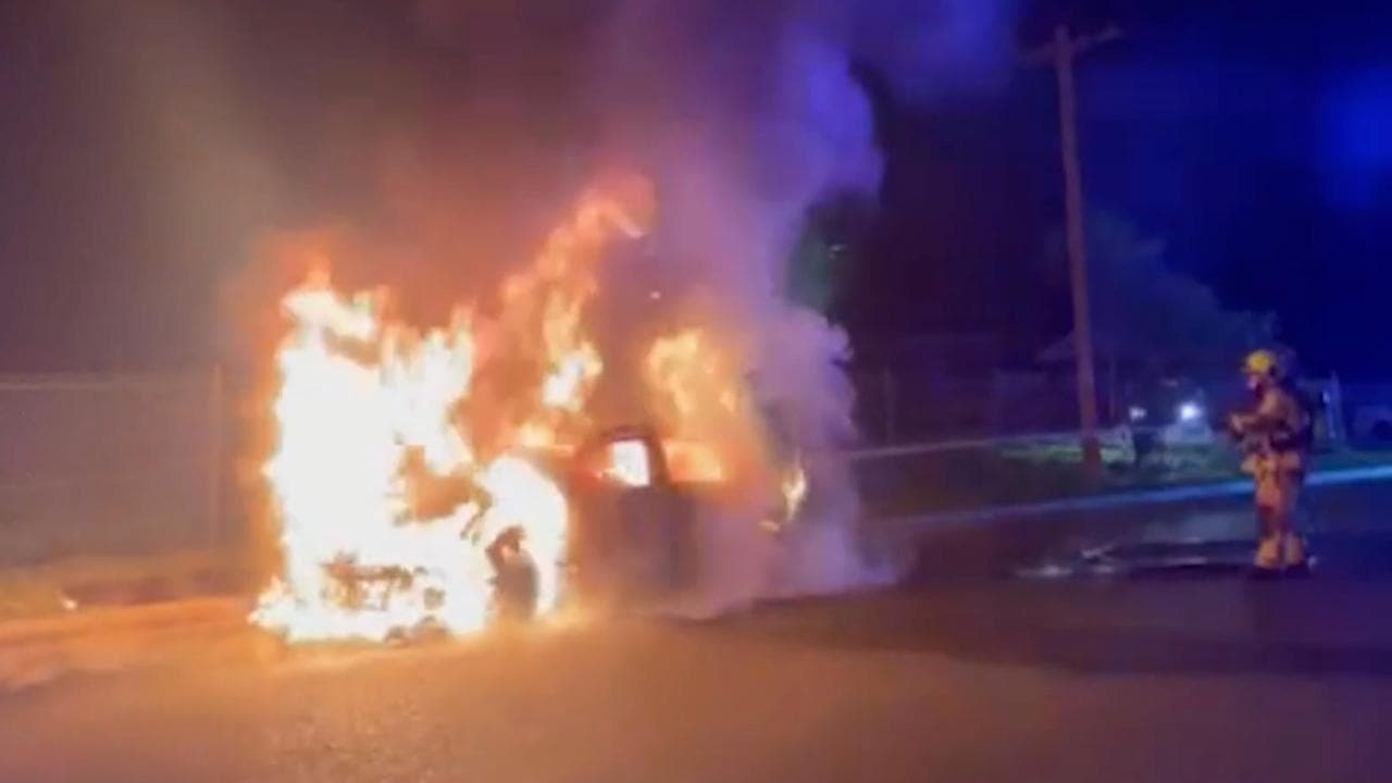 Firefighters attend a burning car in Granville