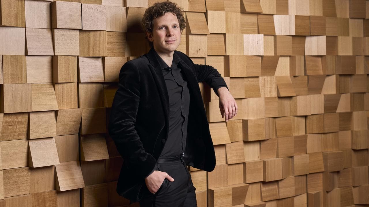 Jayson Gillham leans against a wall.