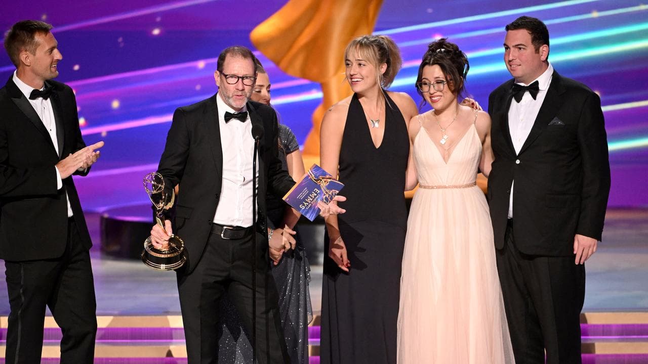 People accept an award on a stage.