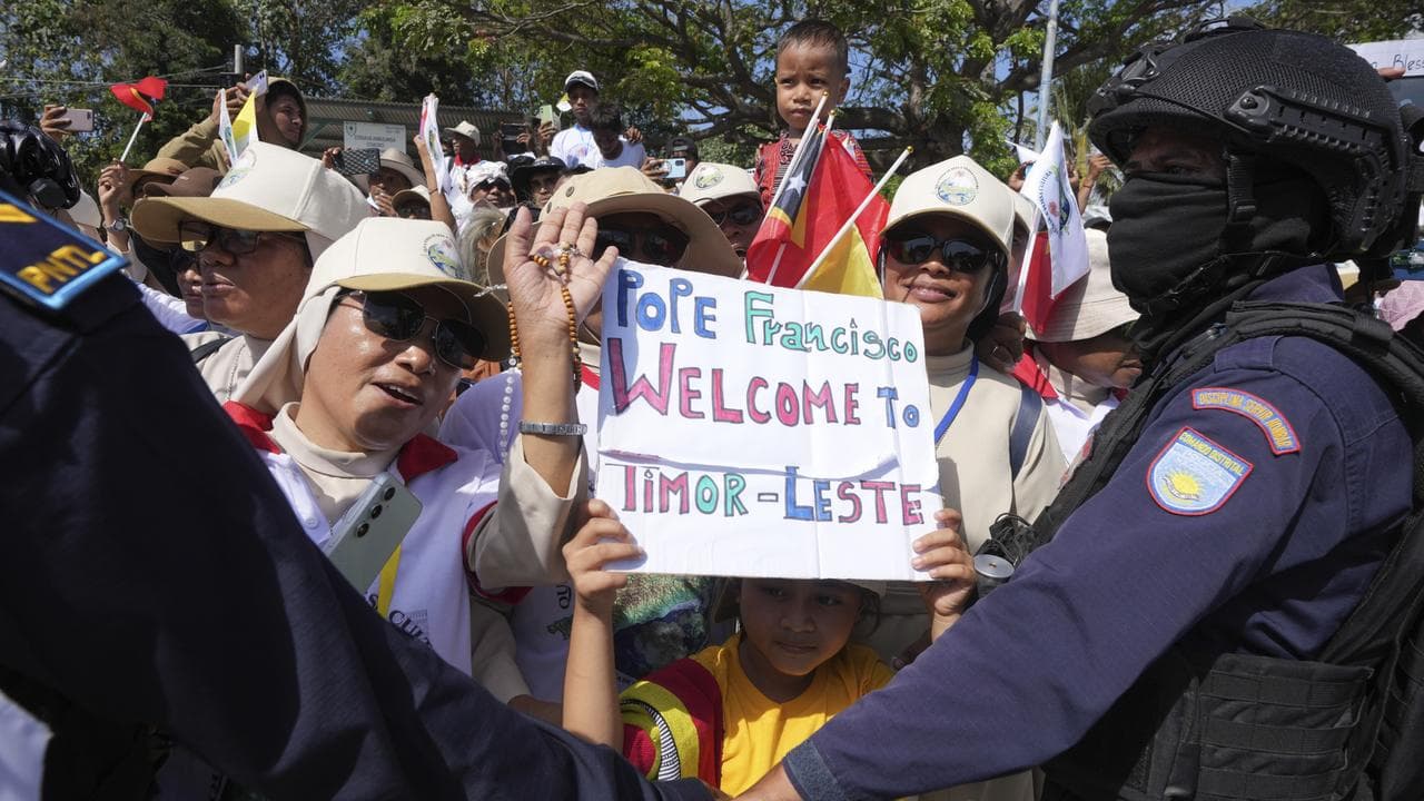 A child holds a welcome sign for Pope Francis in Dili, East Timor