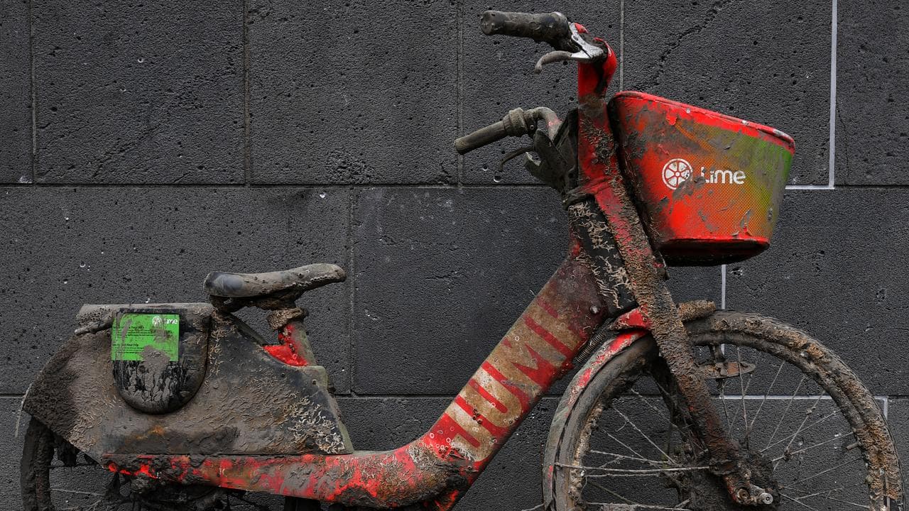 A Lime electric-assist bike, covered in mud