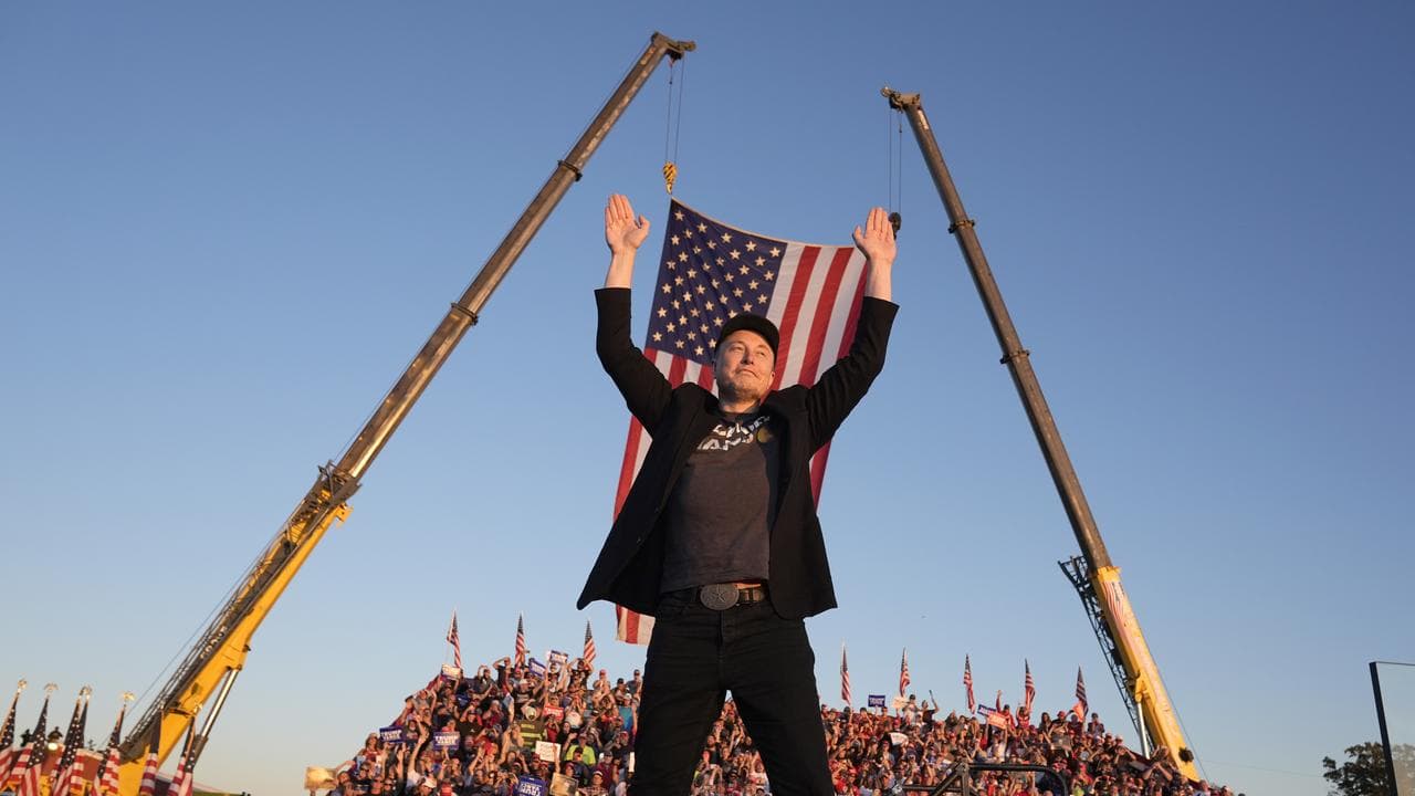 Elon Musk walks to the stage to speak alongside Donald Trump