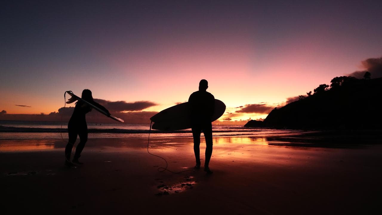 Surfers are seen at sunrise (file image)