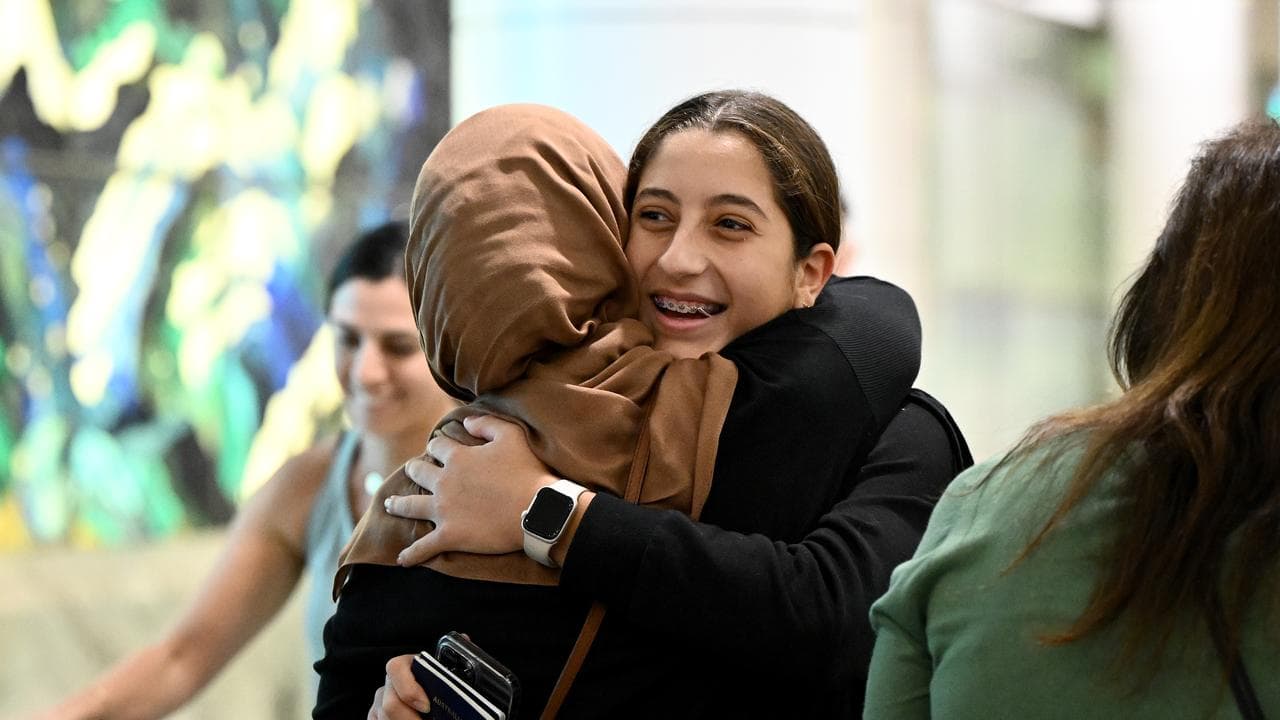 People embrace as Australian nationals arrive on a repatriation flight