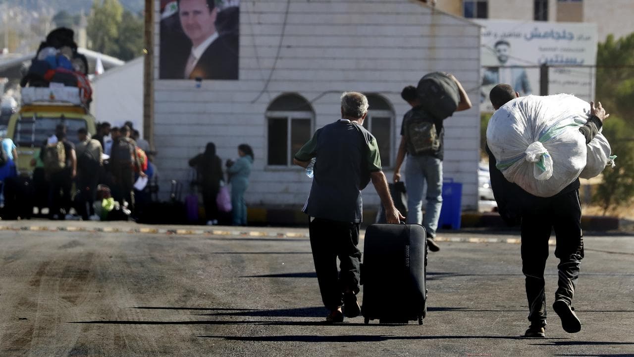 Syrians who fled the war in Lebanon arrvie in Jdeidet, Syria