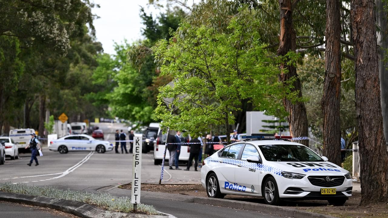 Police cordon on suburban street.