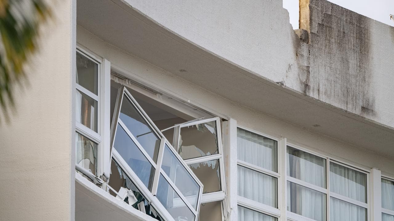 A broken window and damaged rooftop at a hotel