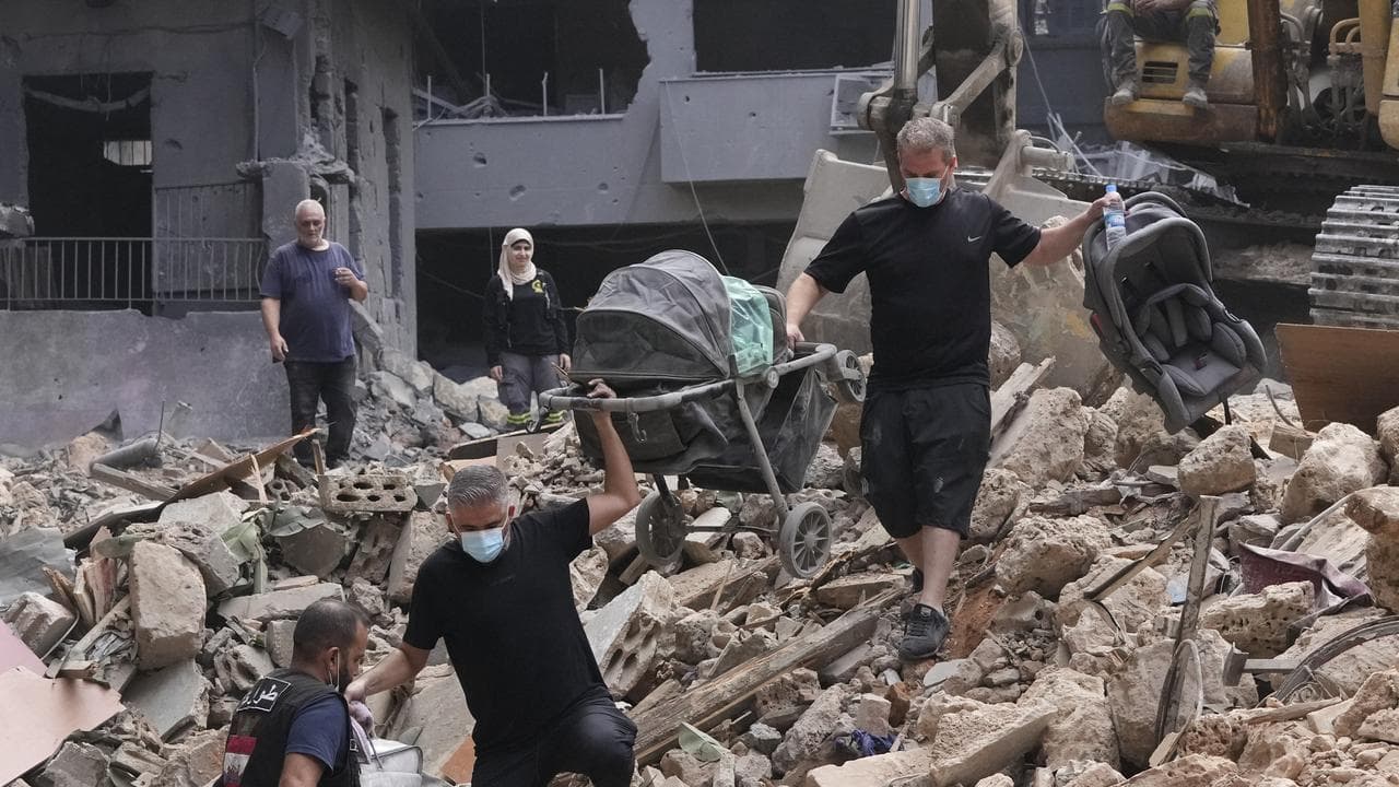 Residents of a damaged building collect belongings