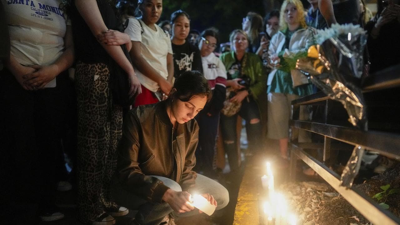 Fans light candles outside the hotel where Liam Payne died
