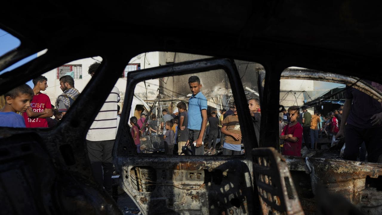 Palestinians view damage from an Israeli strike in the Gaza Strip