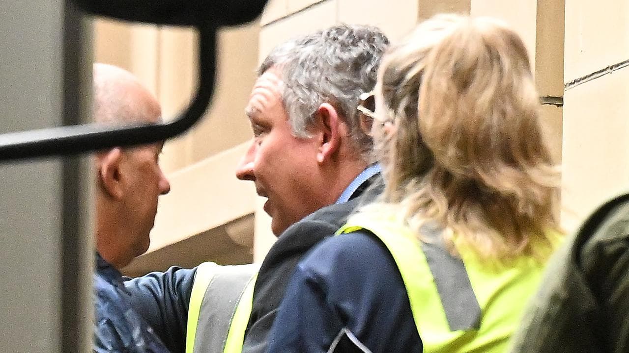 Greg Lynn (centre) being led away from court.