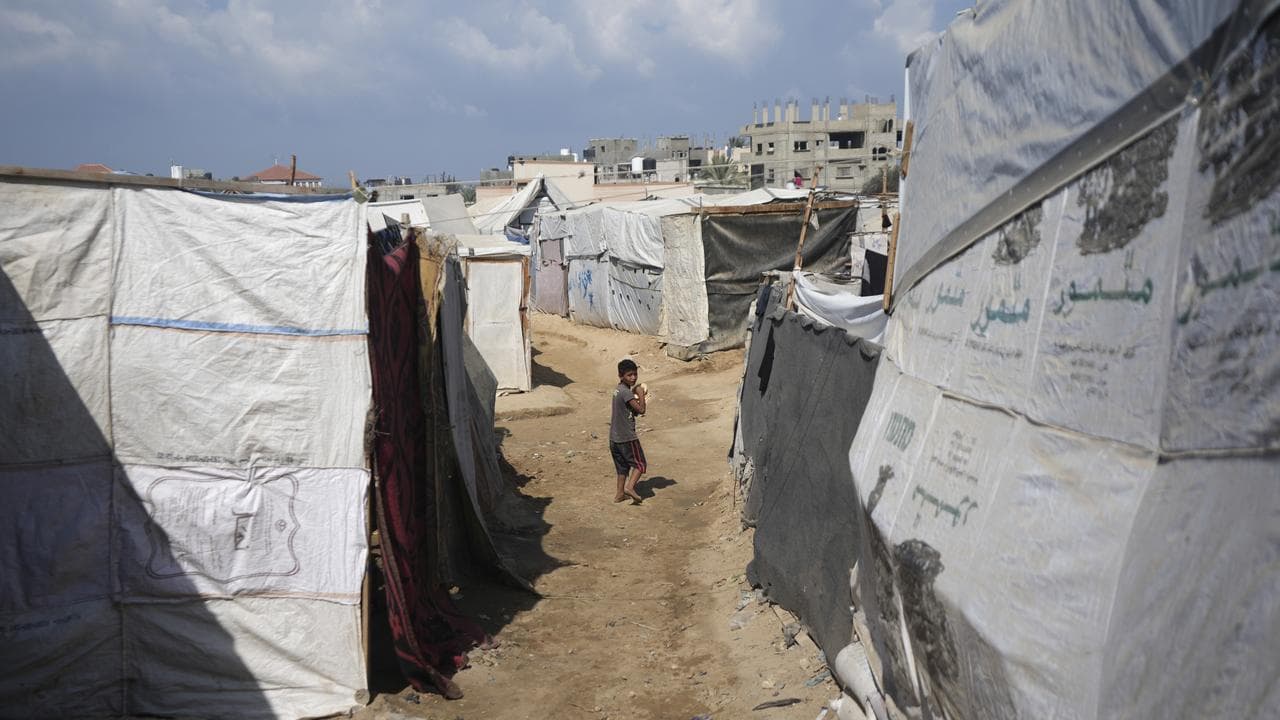 Displaced Palestinian boy between tents in Deir al-Balah, Gaza Strip