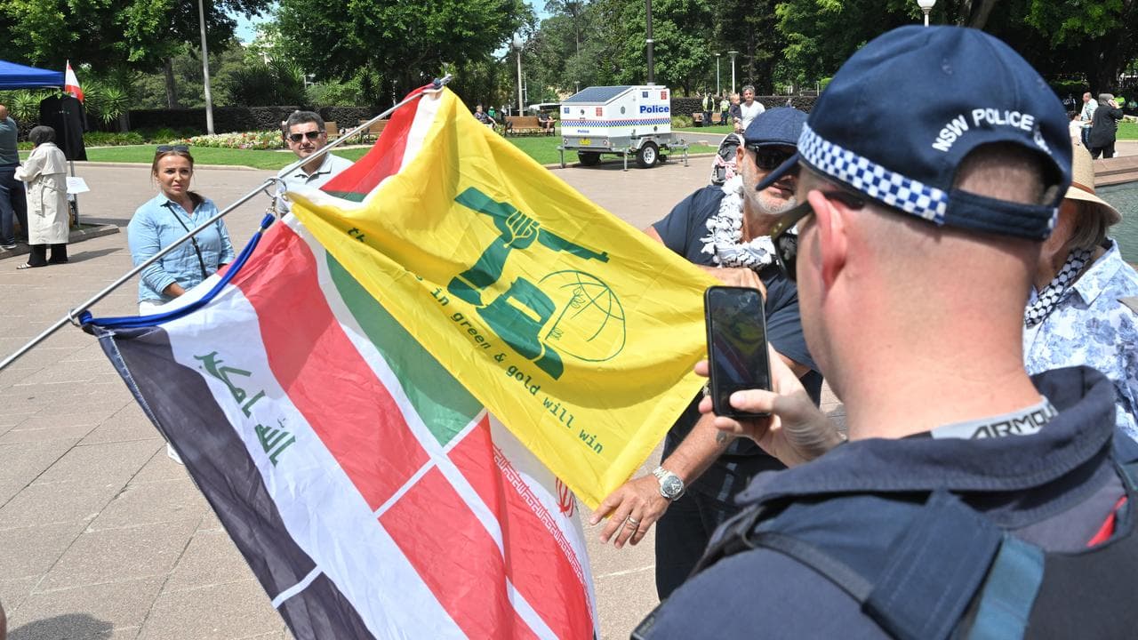Police check flags at pro-Palestine rally on October 6