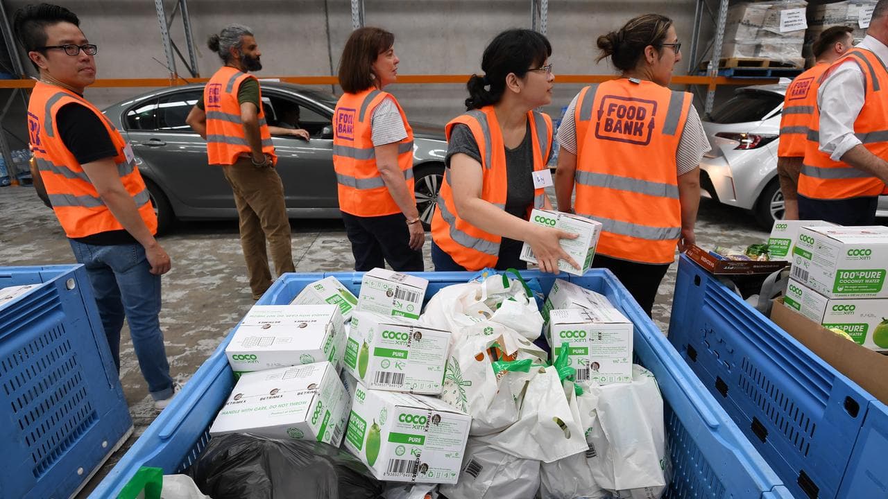 Volunteers sort food donations during a tour of Foodbank Victoria