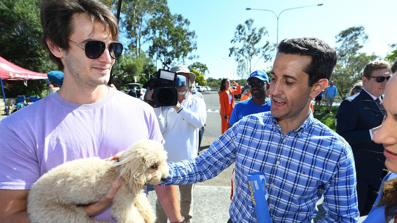David Crisafulli talks to a voter with his dog at a booth in Nerang