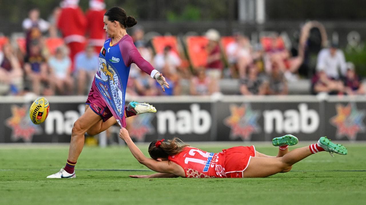 Sophie Conway (left) of the Lions gets past Ella Heads.