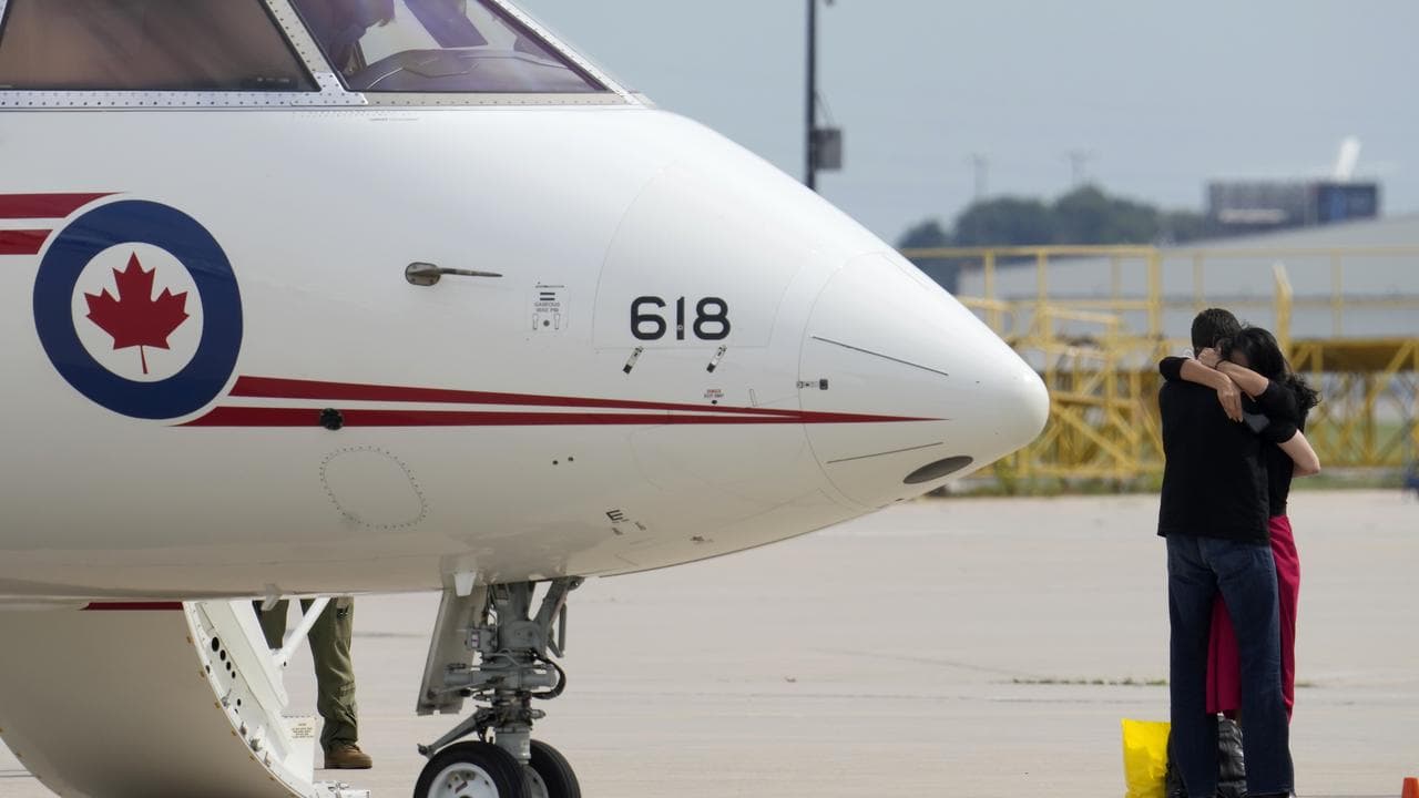Michael Kovrig embraces his wife after arriving in Toronto in 2021