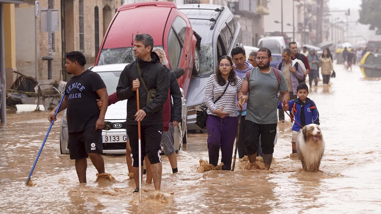 People walk through flooded streets in Valencia, Spain