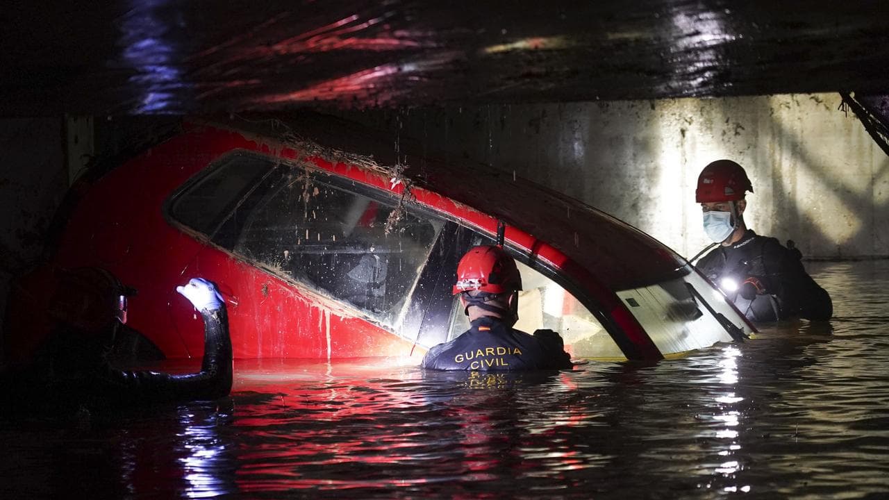 Searchers in a flooded car park in Paiporta, near Valencia