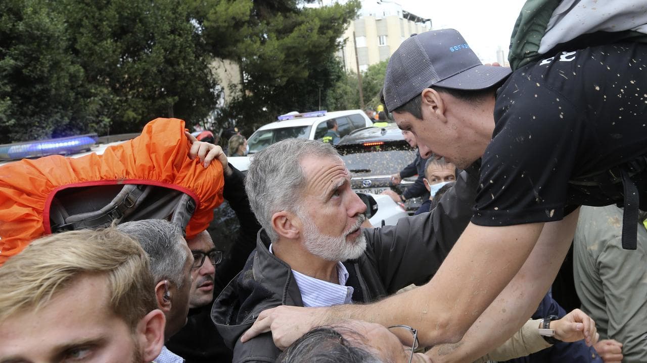 Spain's King Felipe VI listens to a person affected by the floods