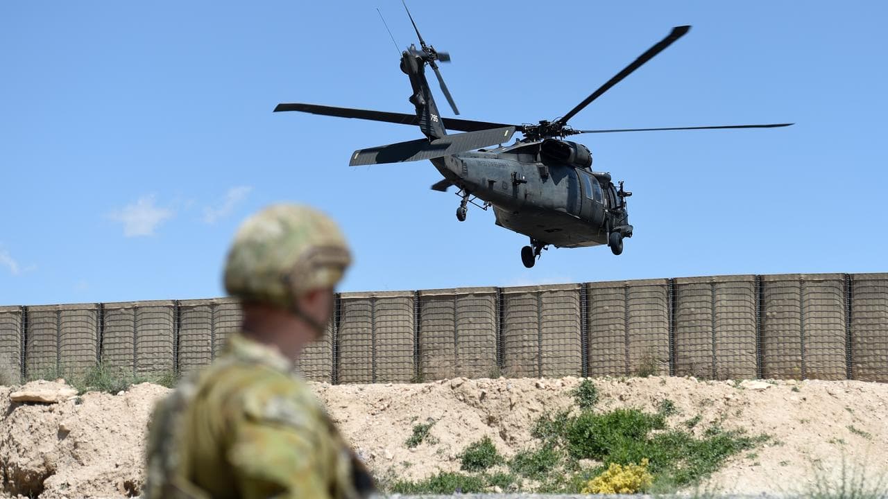 An ADF member watches as a Black Hawk helicopter (file image)