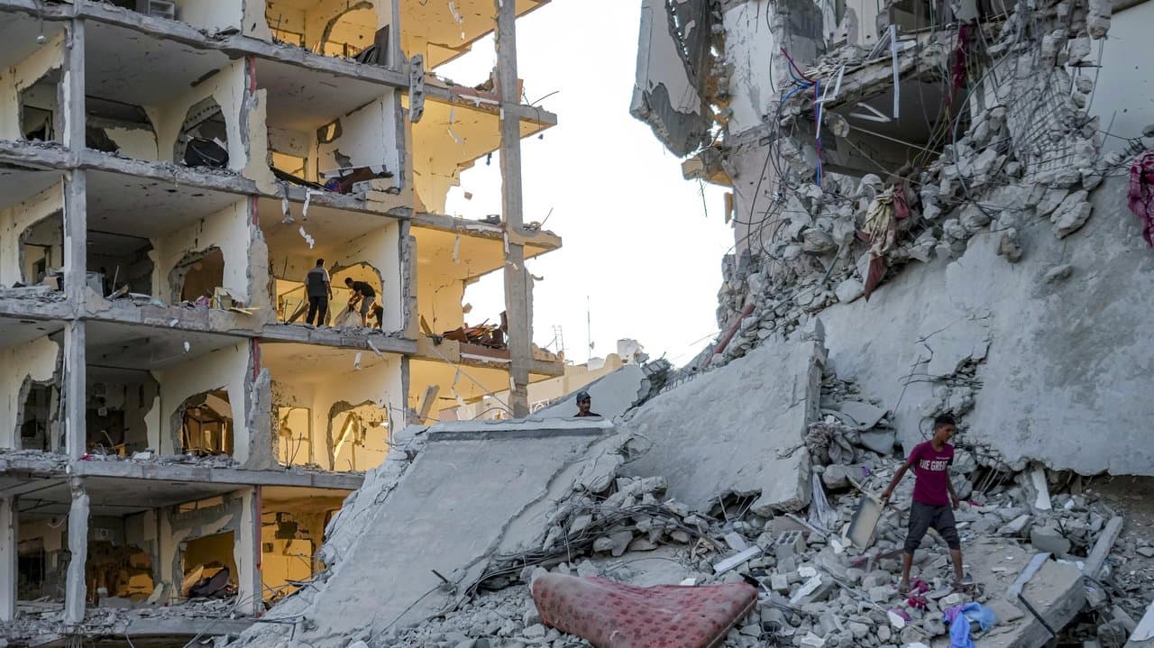 Palestinians inspect their houses after bombardment on Deir al-Balah