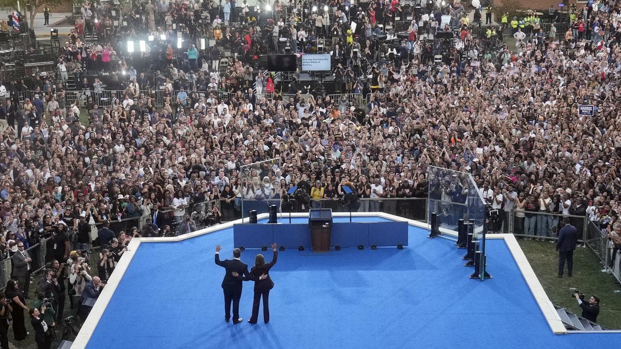 Vice President Kamala Harris and her husband wave to the crowd