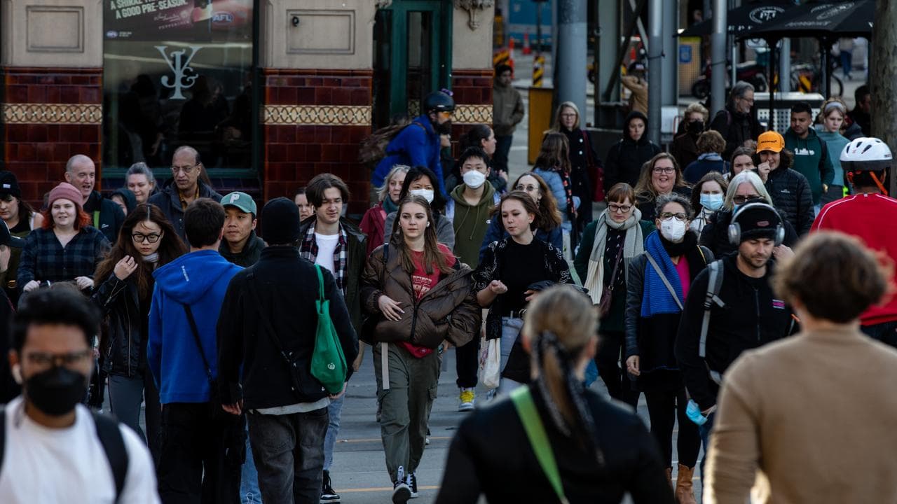 People walk along Flinders Street, Melbourne,