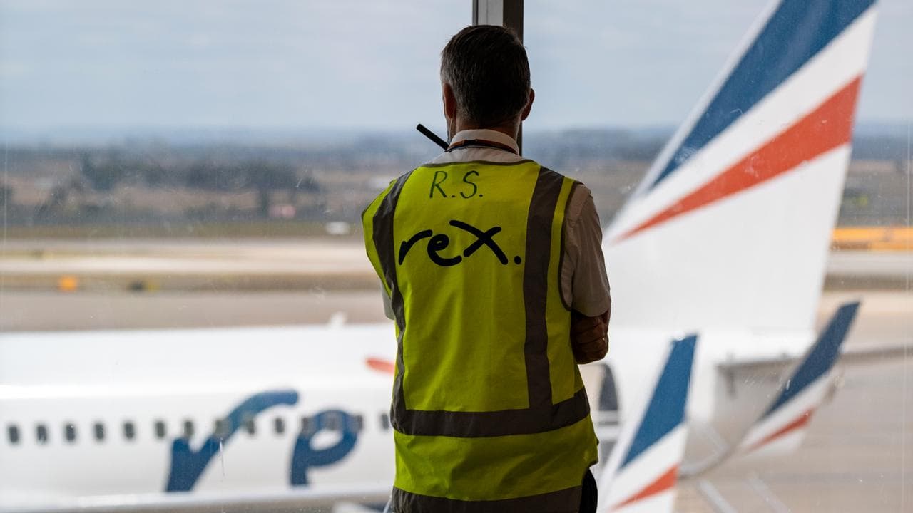 A Rex Airlines worker looks on as a plane arrives