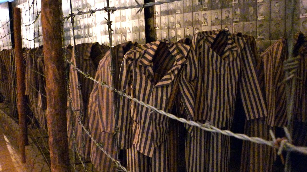Uniforms left to images of victims at Auschwitz