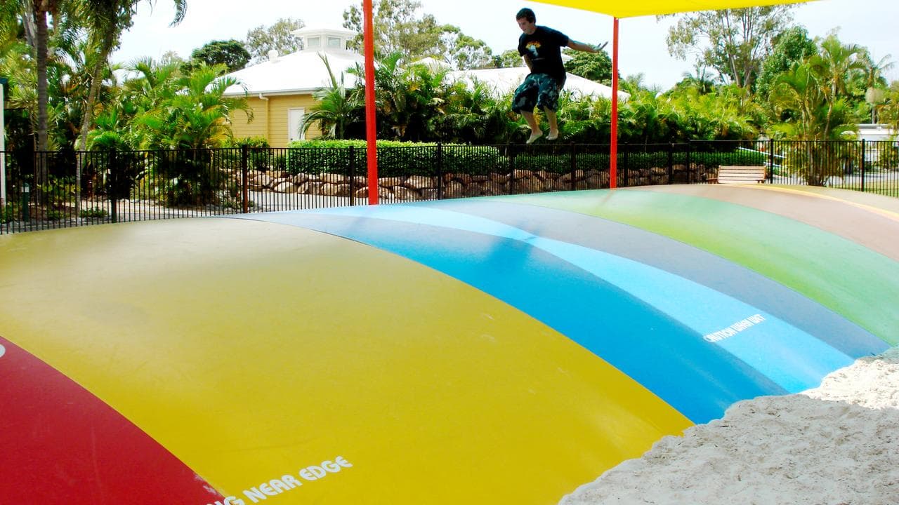 A boy jumps on a bouncy pillow