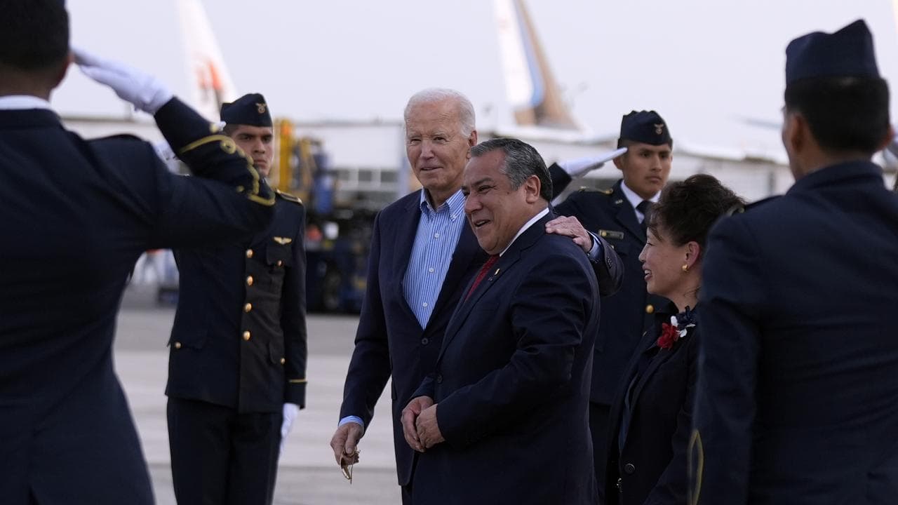 President Joe Biden walks with Peruvian PM Gustavo Adrianzen