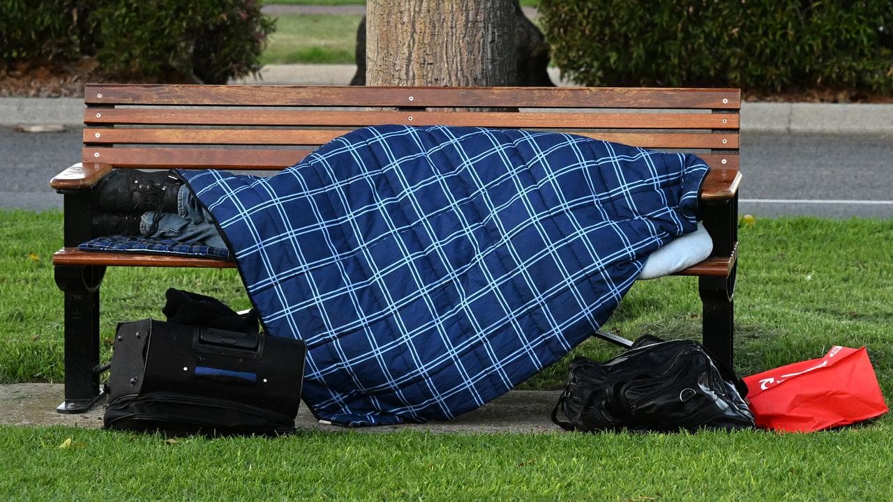 A homeless person is seen sleeping on a park bench in Perth