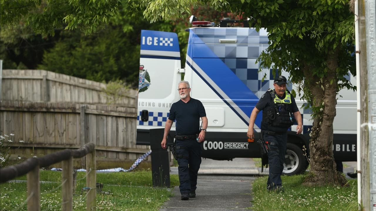 Police outside a home where a woman was stabbed to death