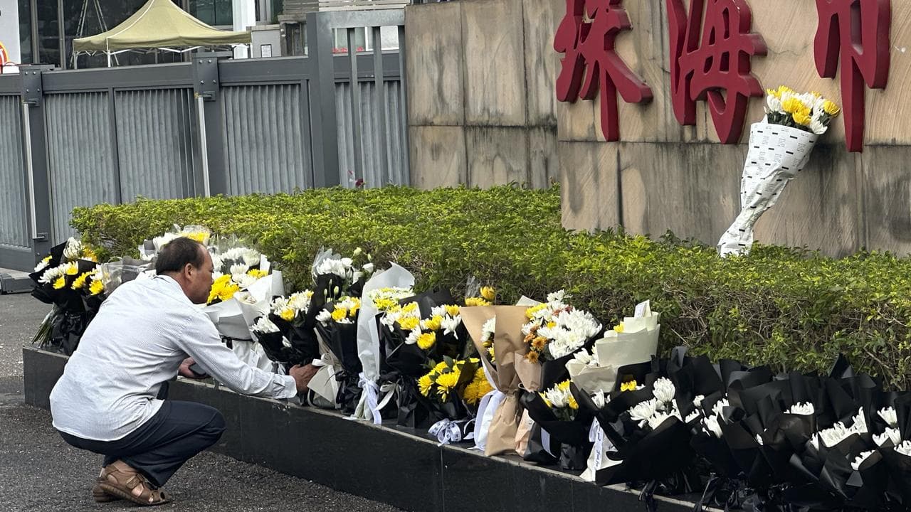 A man lays flowers outside the Zhuhai People's Fitness Plaza