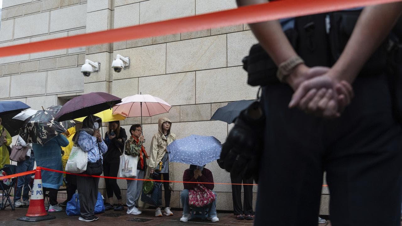 People wait outside the West Kowloon Magistrates' Courts in Hong Kong