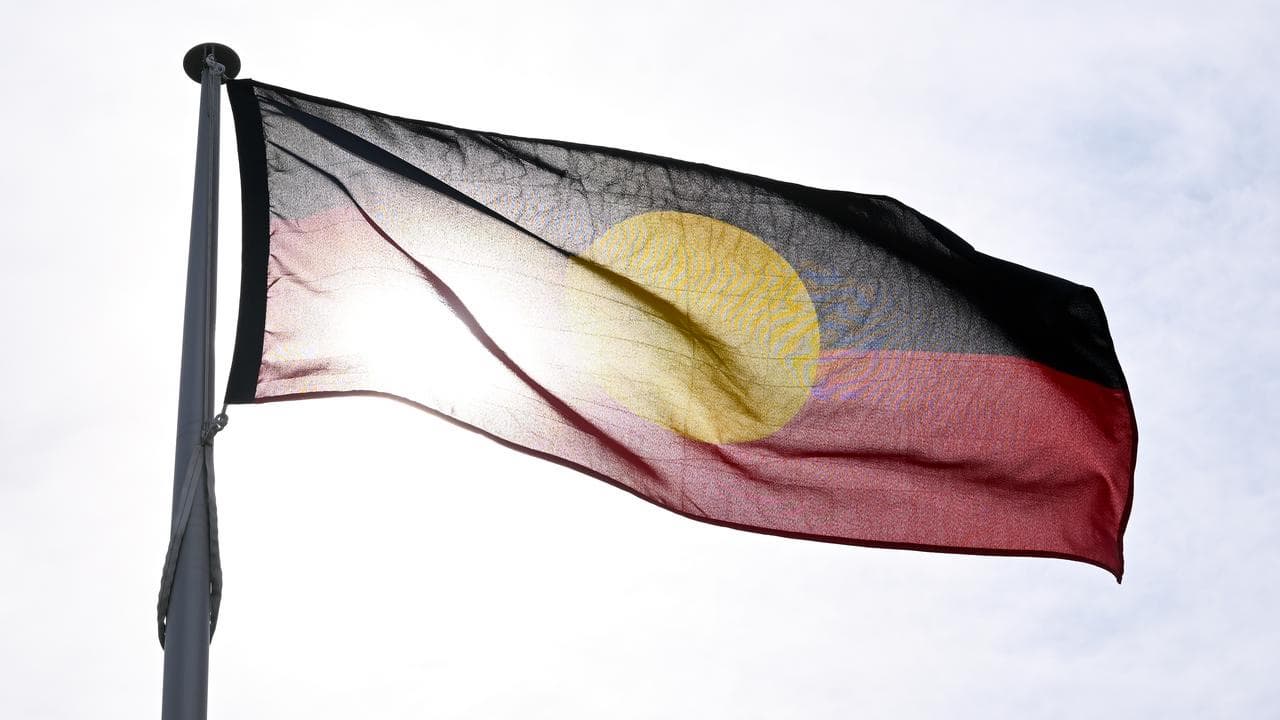 An Aboriginal flag flies in front of the sun