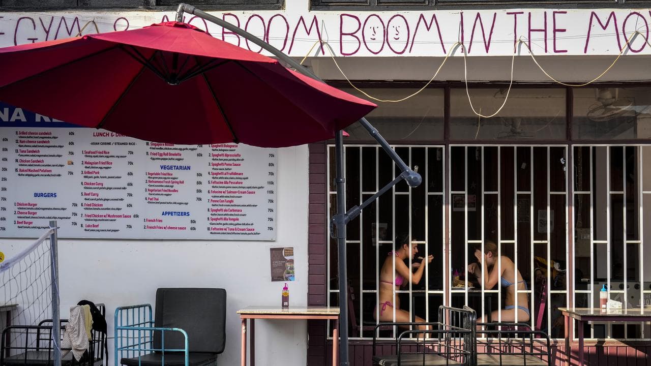 Tourists eat food at Nana Backpack hostel in Vang Vieng, Laos