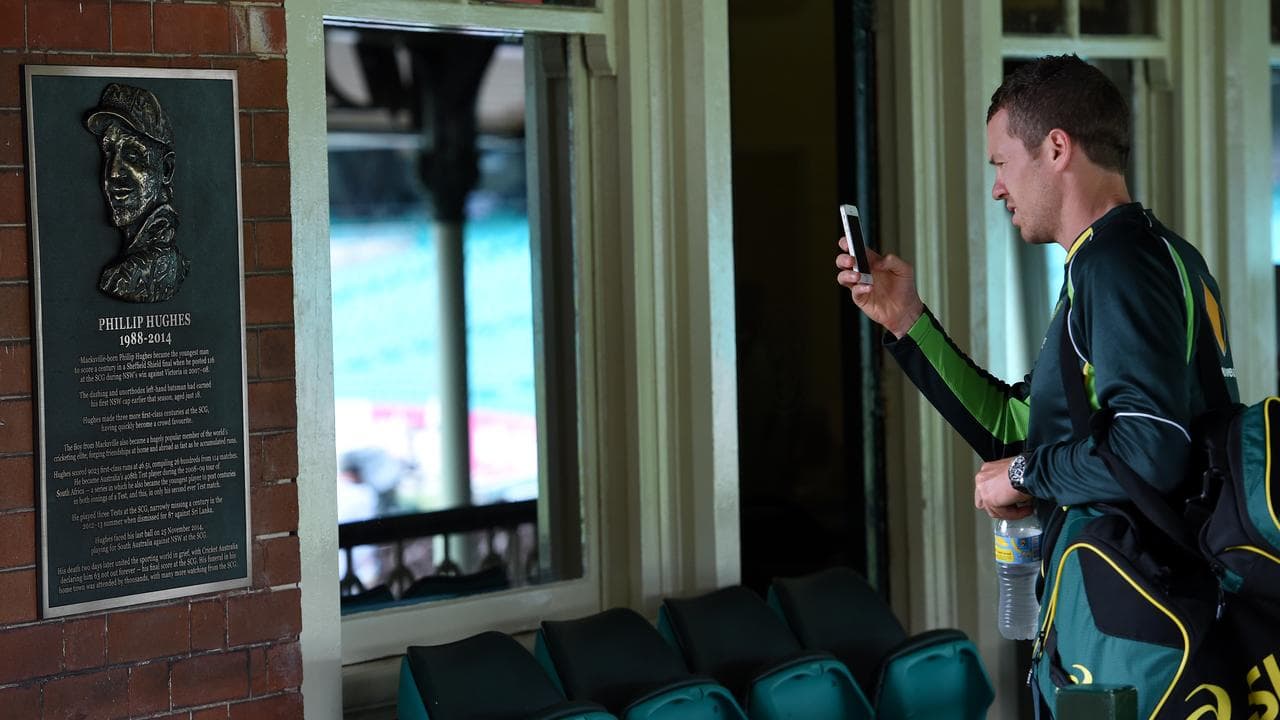 Peter Siddle snaps the plaque commemorating Hughes at the SCG.