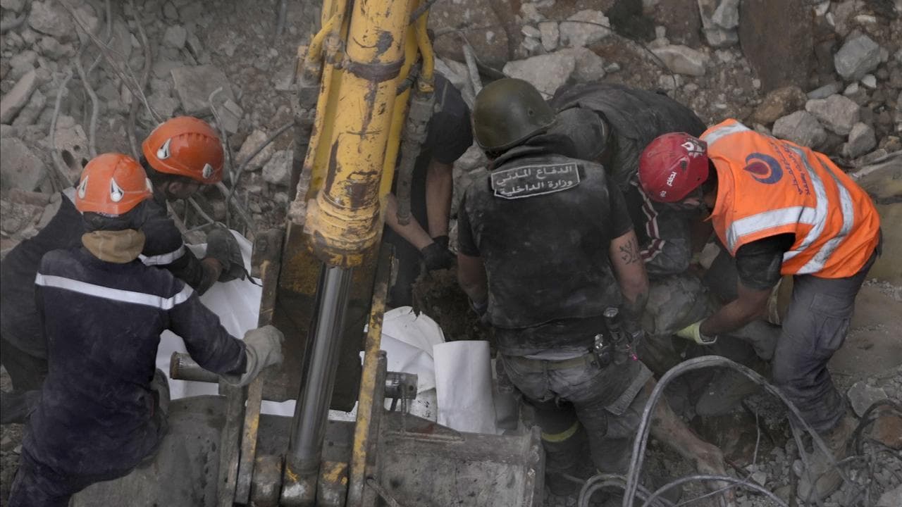 Rescue workers retrieve a body from the rubble of a building 