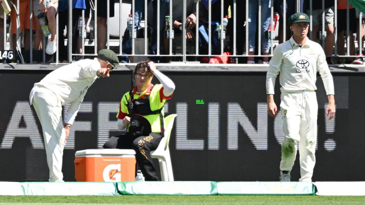Nathan Lyon helps a security guard.