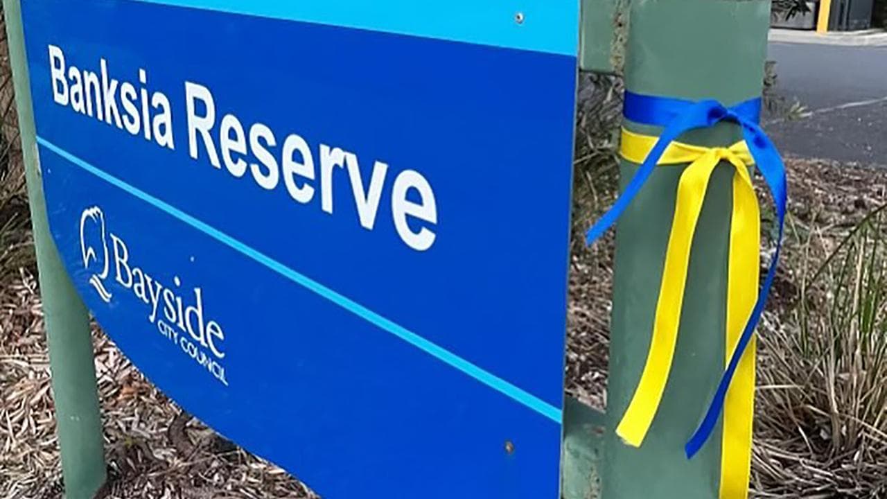 Sign with yellow and blue ribbons 