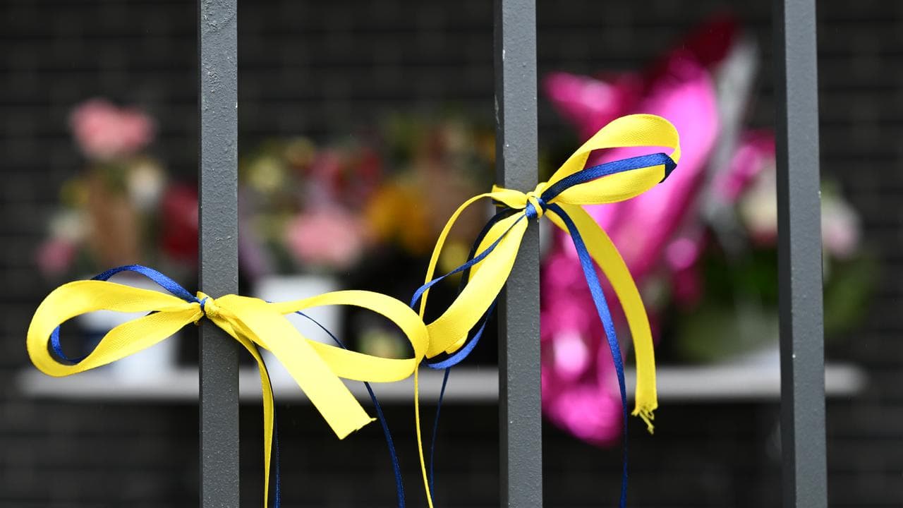 Blue and yellow ribbons on fence