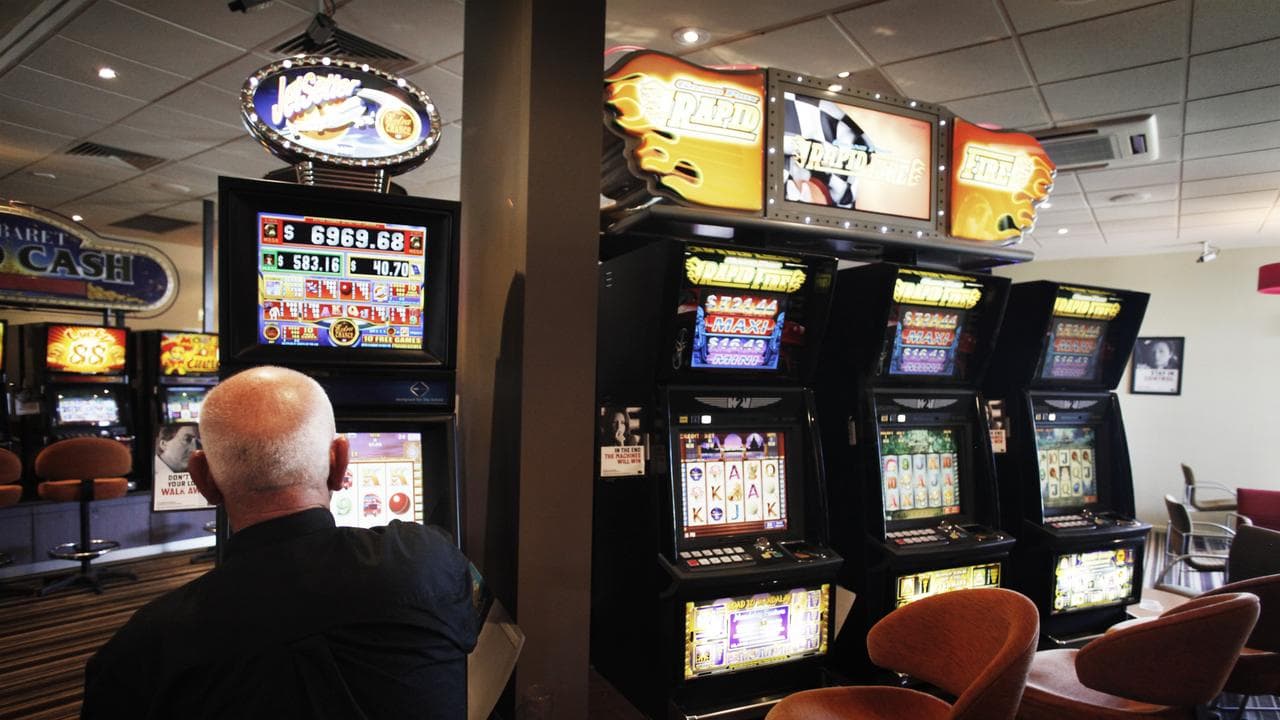 A man plays a pokie machine (file image)