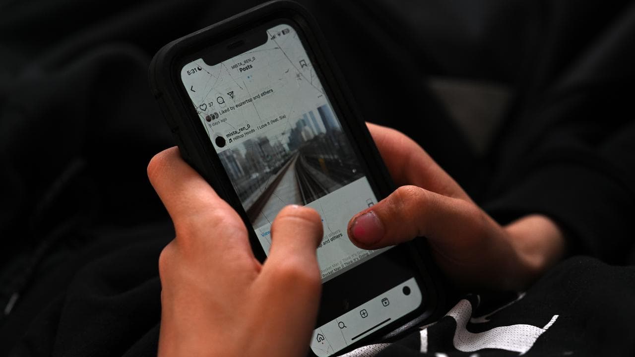 A teenager uses his mobile phone to access social media, Sydney
