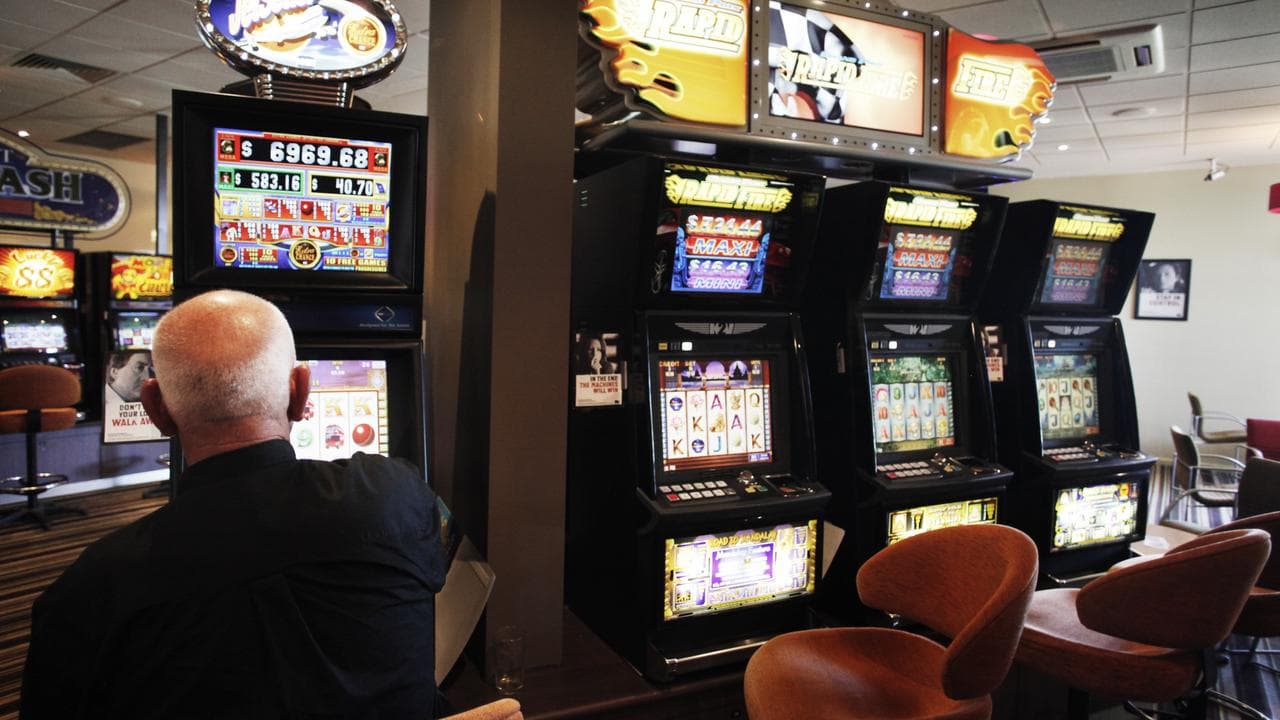 A man plays a pokie machine at a club in Altona, Melbourne