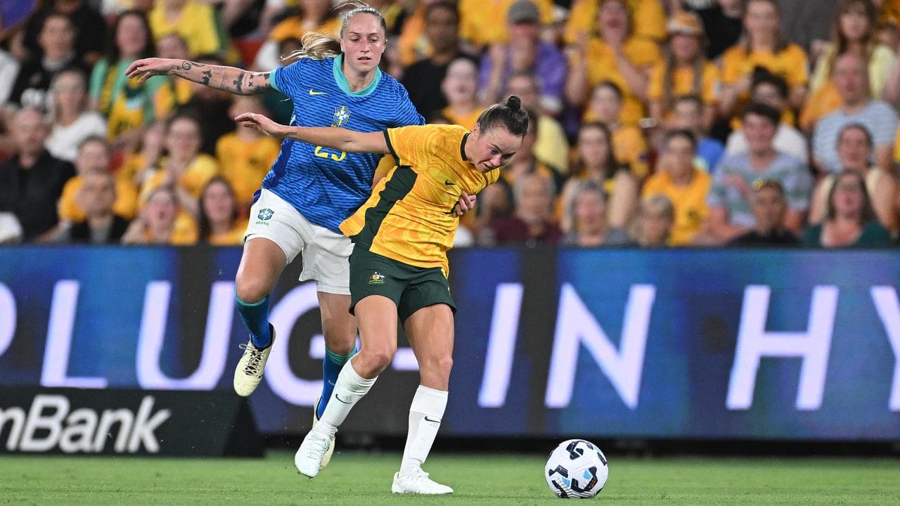 Isadora Haas Gehlen of Brazil holds Matildas star Caitlin Foord.